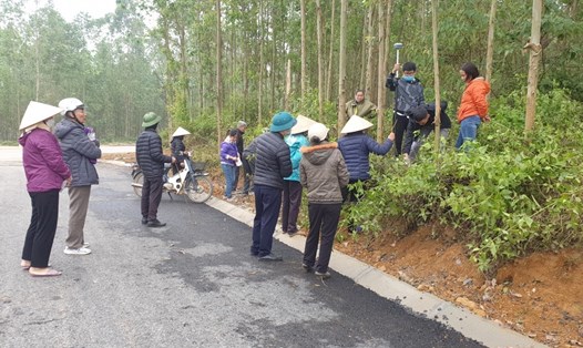 Cán bộ địa chính thị trấn Hưng Hoá cùng người dân tiến hành đo đạc diện tích đất bị san gạt trái phép. Ảnh: Phóng viên Lao Động