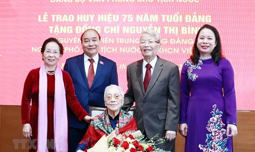 Chủ tịch nước Nguyễn Xuân Phúc và các đại biểu tại lễ trao tặng huy hiệu 75 năm tuổi Đảng cho bà Nguyễn Thị Bình - nguyên Ủy viên Trung ương Đảng, nguyên Phó Chủ tịch nước Việt Nam tháng 10.2021. Ảnh: TTXVN