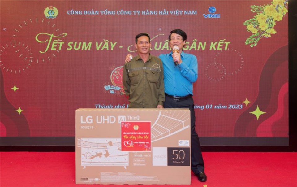 Chủ tịch Công đoàn Tổng Công ty Hàng hải Việt Nam Lê Phan Linh trao thưởng cho người lao động (bên trái) tại nội dung "Quay số may mắn". Ảnh: Linh Chu