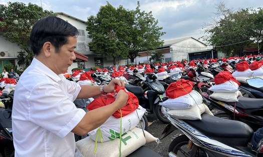 Ông Trần Duy Khanh - Giám đốc Nhà máy Đồng Xoài Công ty Cổ phần Đầu tư Thái Bình - xếp quà Tết lên xe máy cho công nhân lao động. Ảnh: Thanh Nga