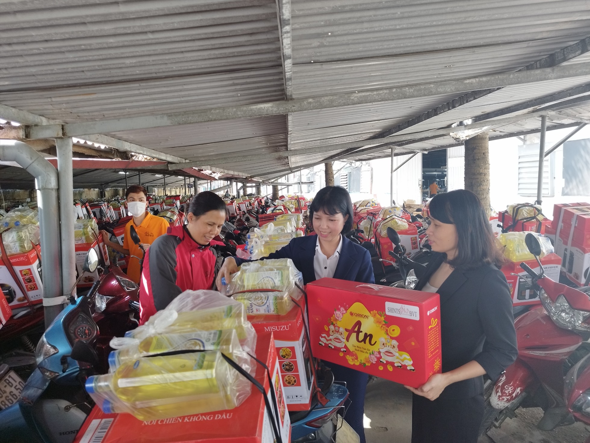 Công ty TNHH Shints BVT hỗ trợ CNLĐ buộc quà vào xe. Ảnh: Diệu Thuý