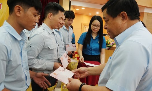 Bộ trưởng Bộ KHĐT Nguyễn Chí Dũng trao quà cho công nhân khó khăn ở Vũng Áng. Ảnh: Trần Tuấn