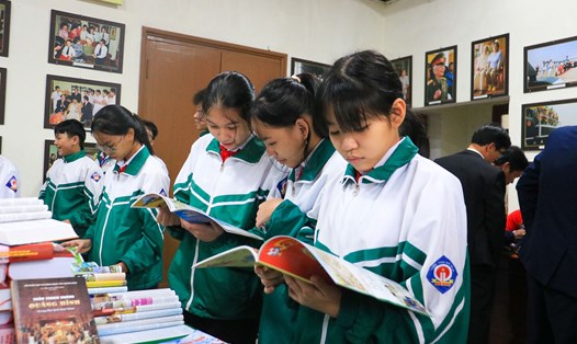 Các em học sinh chăm chú đọc các ấn phẩm tại Hội báo Xuân. Ảnh: Đ.T