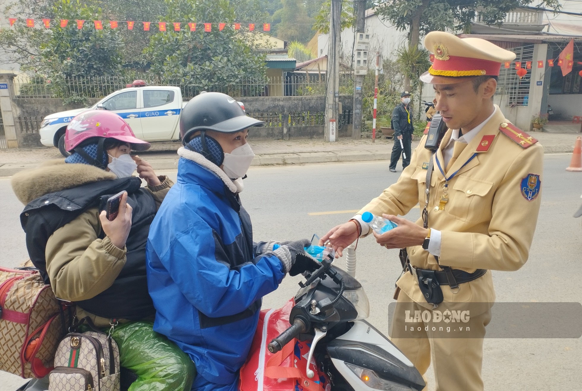 Lực lượng cảnh sát giao thông Yên Bái lập nhiều điểm phát nhu yêu phẩm và hỗ trợ người dân đi làm ăn xa về quê ăn Tết. Ảnh: Văn Đức.