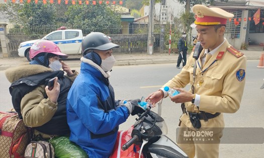 Lực lượng cảnh sát giao thông Yên Bái lập nhiều điểm phát nhu yêu phẩm và hỗ trợ người dân đi làm ăn xa về quê ăn Tết. Ảnh: Văn Đức.