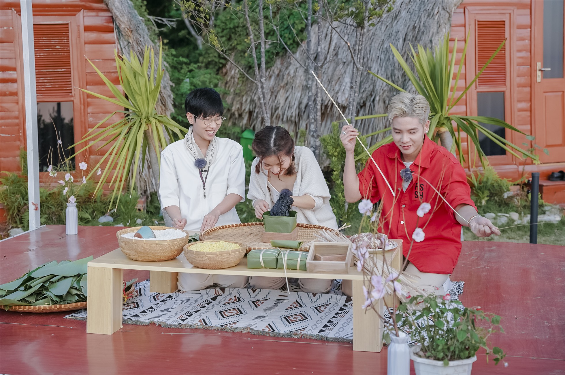 Tiên Cookie, Lâm Bảo Ngọc và Quân A.P hào hứng thử sức gói bánh chưng. Ảnh: Ban tổ chức