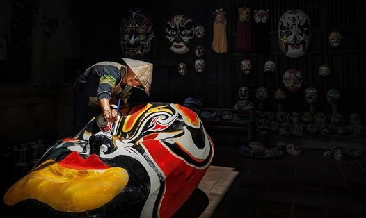 Nghệ nhân Bùi Quý Phong cùng chiếc mặt nạ thời gian cỡ đại. Ảnh: Son Ca