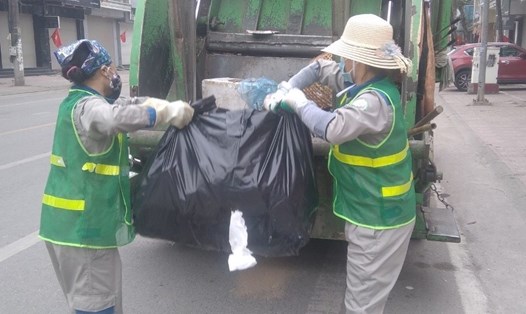 Chị Nguyễn Thị Xoan cùng đồng nghiệp thu dọn rác đường phố vào sáng mồng 1 Tết. Ảnh: NVCC