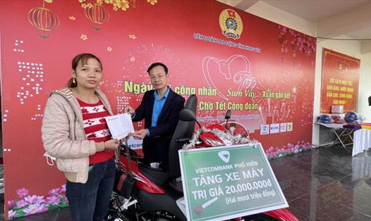 Ban tổ chức trao giấy tờ và xe máy cho chị Đặng Thị Ngọc. Ảnh: Hà Anh