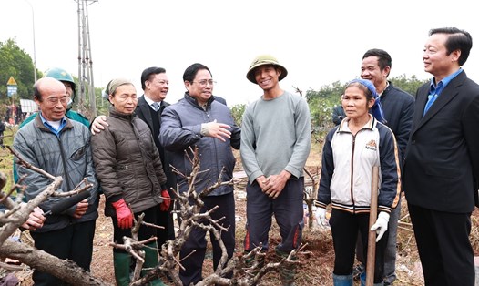 Thủ tướng Phạm Minh Chính thăm hỏi, động viên người dân có đất trong diện giải phóng mặt bằng phục vụ dự án tại xã Song Phương, huyện Hoài Đức. Ảnh: Dương Giang