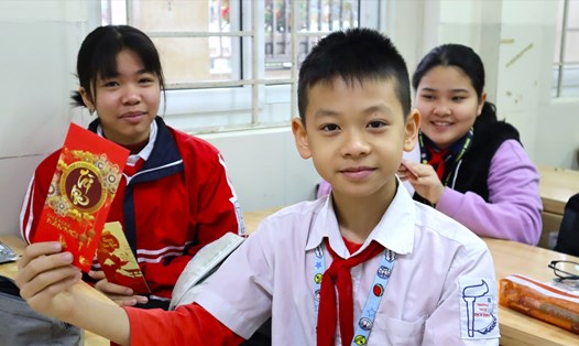 Học sinh Hà Nội được giáo viên lì xì vào ngày đầu đi học trở lại sau kỳ nghỉ Tết Nguyên đán. Ảnh: Minh Hà