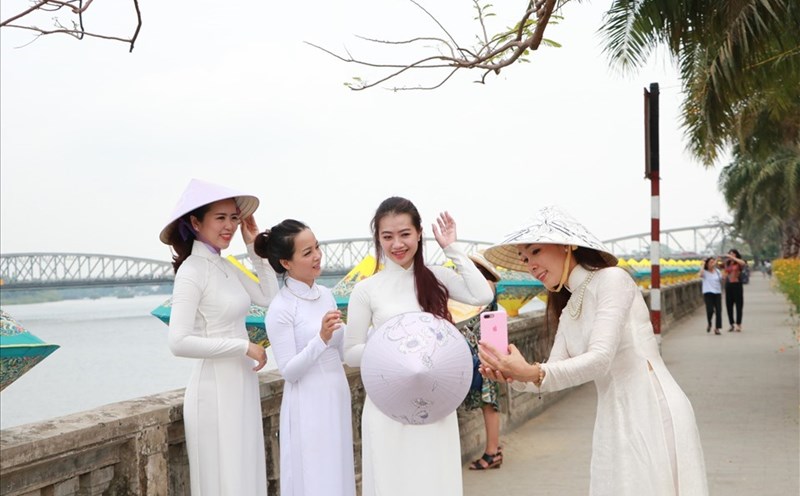 Du khách mặc áo dài dạo phố. Ảnh: P. Đạt.