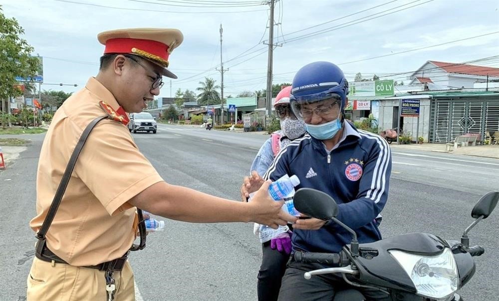 Người lao động nhận quà hỗ trợ từ CSGT trên đường trở lại nhà máy sau kỳ nghỉ Tết. Ảnh: Nhật Hồ