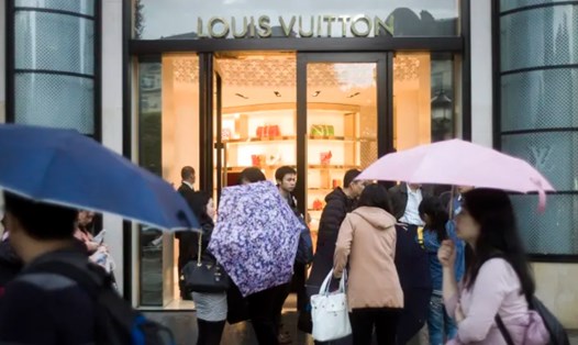 Khách du lịch Trung Quốc trước cửa hàng Louis Vuitton trên đại lộ Champs-Elysees ở Paris, Pháp. Ảnh: AFP