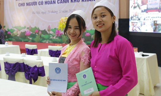 Chị Bùi Thị Hằng - tỉnh Hòa Bình (bên phải) được tặng sổ bảo hiểm xã hội. Ảnh: Anh Thư.