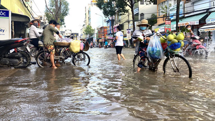 Trên đường Trần Việt Châu (quận Ninh Kiều), những người đi bán hàng rong như trái cây, xôi, bắp,… họ phải dừng lại ngồi trên xe để bán, vì nước ngập sâu không đạp xe đi bán được.