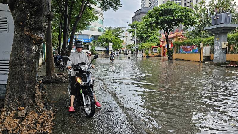 Đường Quốc Hương ngập sâu khiến người người phải chạy xe máy lên vỉa hè chờ nước rút mới đi tiếp.