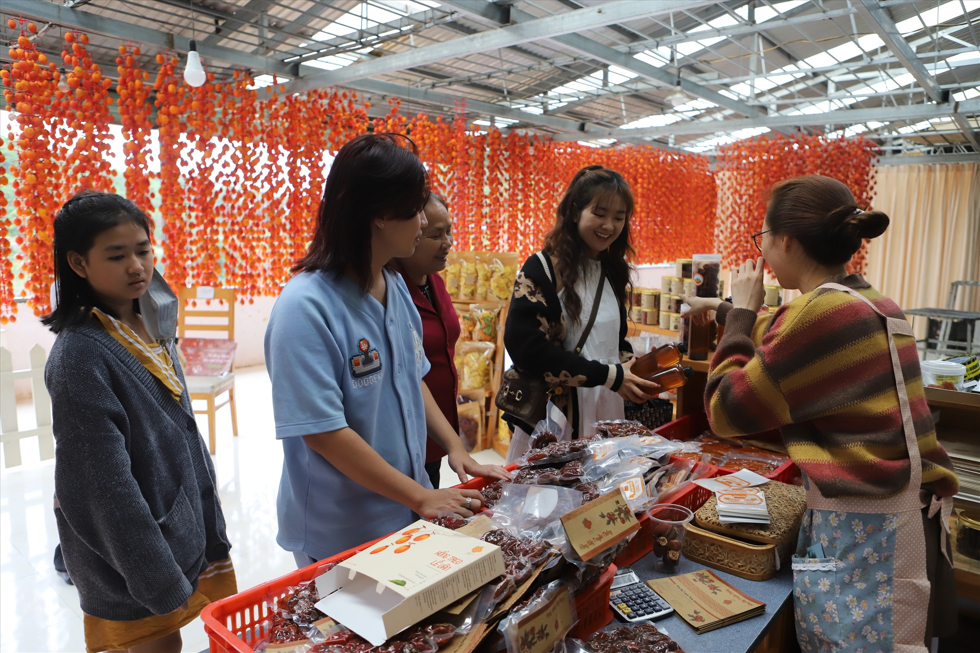 Bên cạnh việc khám phá quy trình sản xuất, du khách cũng được mua và dùng thử sản phẩm hồng treo gió Đà Lạt. Ảnh: Thu Cúc
