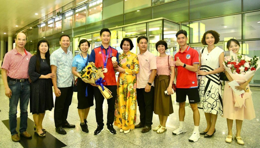 Gia đình và bạn bè Bố mẹ đón xạ thủ Phạm Quang Huy tại sân bay. Ảnh: Cục TDTT  
