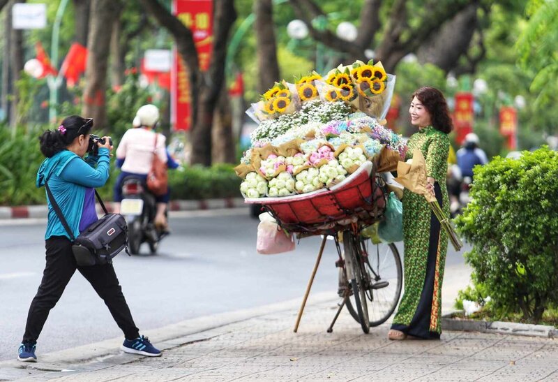 Mùa thu với những chiếc xe chở hoa đã trở thành “đặc sản” của Hà Nội. Trong tiết trời se lạnh, nhiều người đã chọn cho mình chiếc áo dài xuống phố và ghi lại những bức ảnh kỷ niệm.