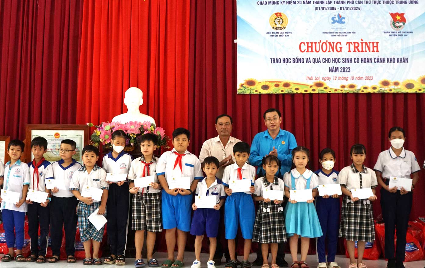 Chủ tịch LĐLĐ huyện Thới Lai Phan Thanh Sang và  trao học bổng cho các em học sinh. Ảnh: Mỹ Ly