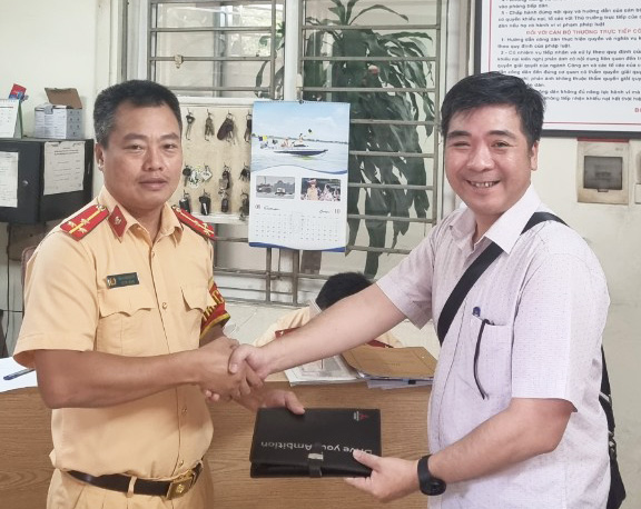 Anh Phạm Hoài Nam nhận lại giấy tờ đánh rơi từ Thượng úy Bùi Kiên Quyết. Ảnh: Hùng Nguyễn