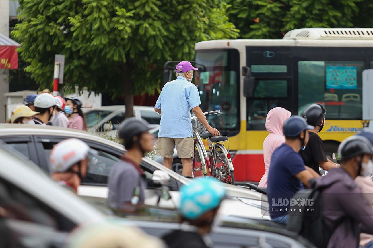 Một số người đi xe đạp nâng xe qua dải phân cách giữa đường Trường Chinh để tránh đoạn ùn tắc.