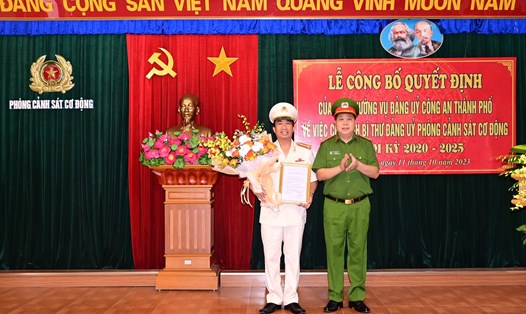 Đại tá Bùi Trung Thành - Phó Giám đốc Công an thành phố trao quyết định và tặng hoa chúc mừng Đại tá Hoàng Văn Nam. Ảnh: Công an TP Hải Phòng
