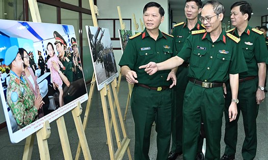 Đại tá Lê Ngọc Long, Phó Tổng biên tập báo Quân đội Nhân dân cùng các đại biểu tham quan triển lãm bên lề cuộc thi ảnh. Ảnh: Hải Nguyễn 