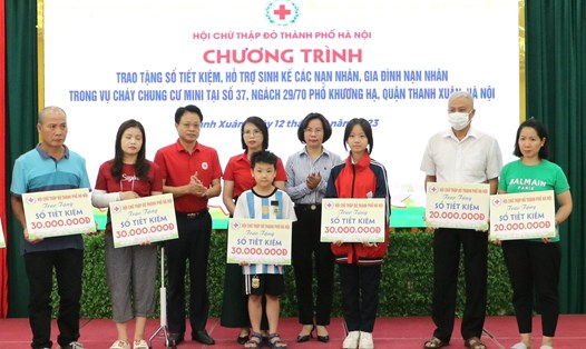 Ông Đào Ngọc Triệu - Chủ tịch Hội Chữ thập đỏ TP Hà Nội  trao tặng sổ tiết kiệm cho các nạn nhân và thân nhân vụ cháy chung cư mini. Ảnh: Hội Chữ thập đỏ TP Hà Nội