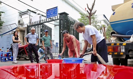 Đều đặn mỗi sáng, người dân tổ dân phố 19, Khu tập thể Đại học Hà Nội đều phải xách xô, chậu lấy nước. Ảnh: Vĩnh Hoàng