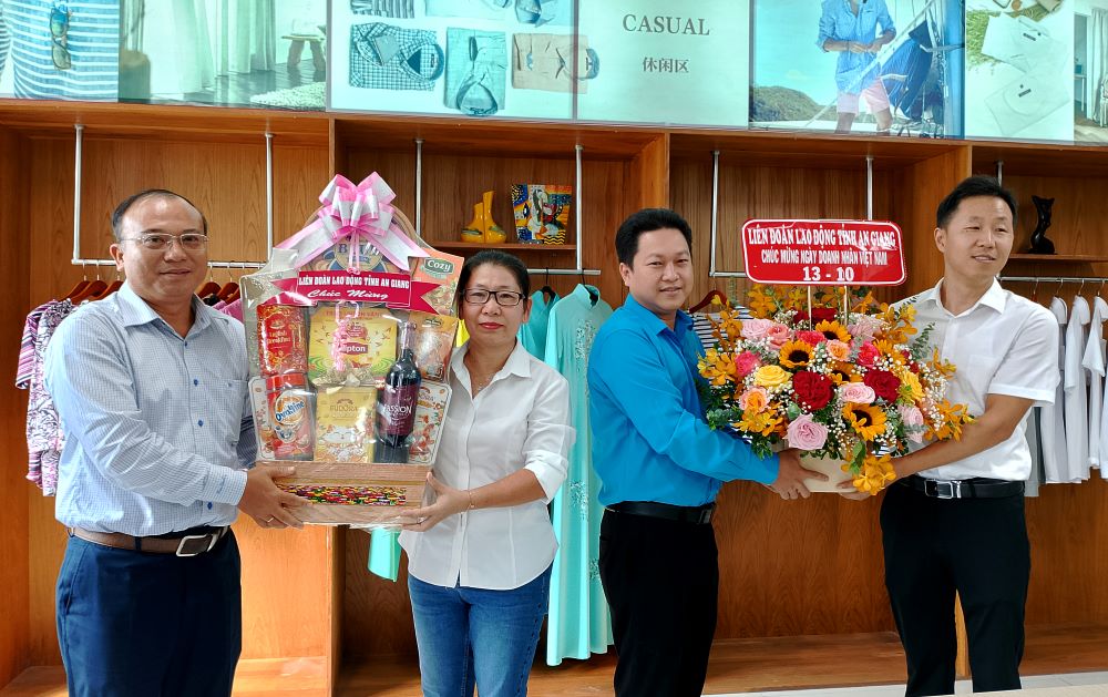 Chủ tịch LĐLĐ tỉnh An Giang Lâm Thành Sĩ (thứ 2, phải sang) tặng quà cho Công ty TNHH May mặc Lu An. Ảnh: Lục Tùng