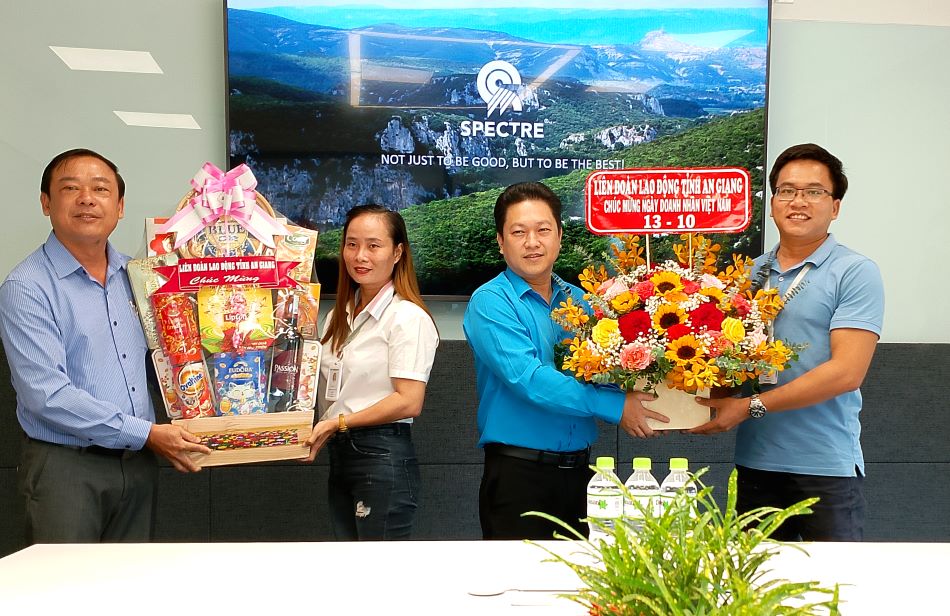 Ông Lâm Thành Sĩ (thứ 2, phải sang) tặng quà cho Công ty TNHH công nghệ May mặc SPECTRE An Giang Việt Nam. Ảnh: Lục Tùng