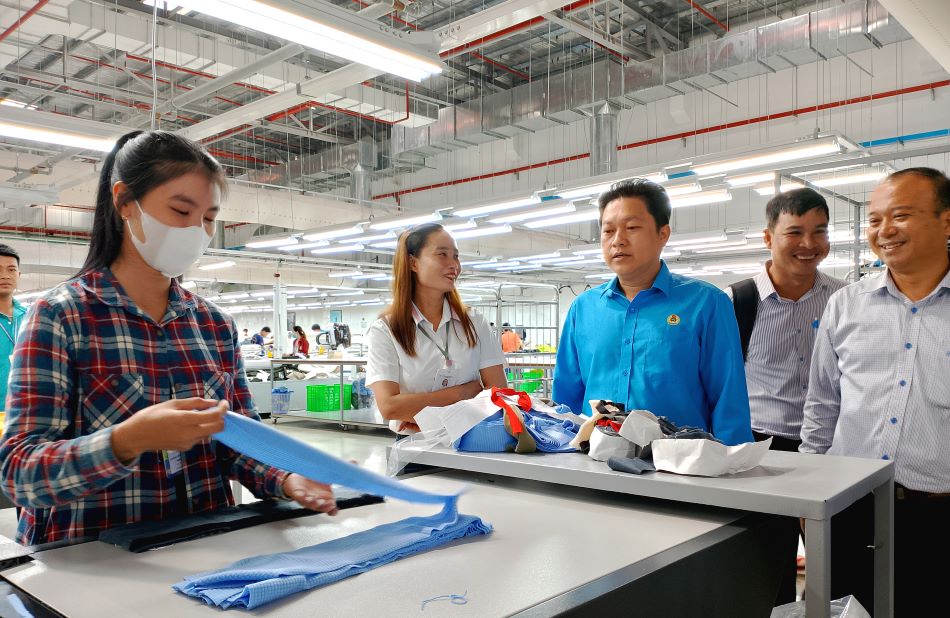 Ông Lâm Thành Sĩ (thứ 3, phải sang) thăm hỏi người lao động đang làm việc tại Công ty TNHH công nghệ May mặc SPECTRE An Giang Việt Nam. Ảnh: Lục Tùng