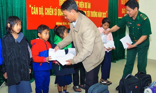 Đại diện Đồn biên phòng cửa khẩu Hồng Vân và chính quyền địa phương trao kinh phí hỗ trợ cho các em học sinh. Ảnh: Hồng Minh