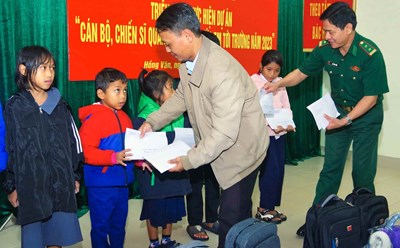 Đại diện Đồn biên phòng cửa khẩu Hồng Vân và chính quyền địa phương trao kinh phí hỗ trợ cho các em học sinh. Ảnh: Hồng Minh