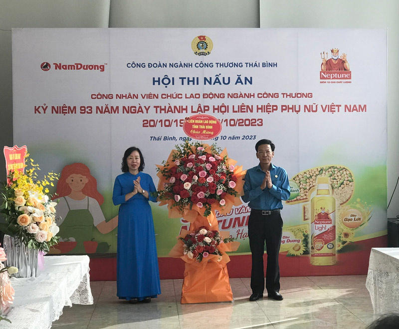 Phó chủ tịch LĐLĐ tỉnh Nguyễn Thanh Bình tặng hoa chúc mừng hội thi nấu ăn Công đoàn ngành Công Thương. Ảnh Bá Mạnh