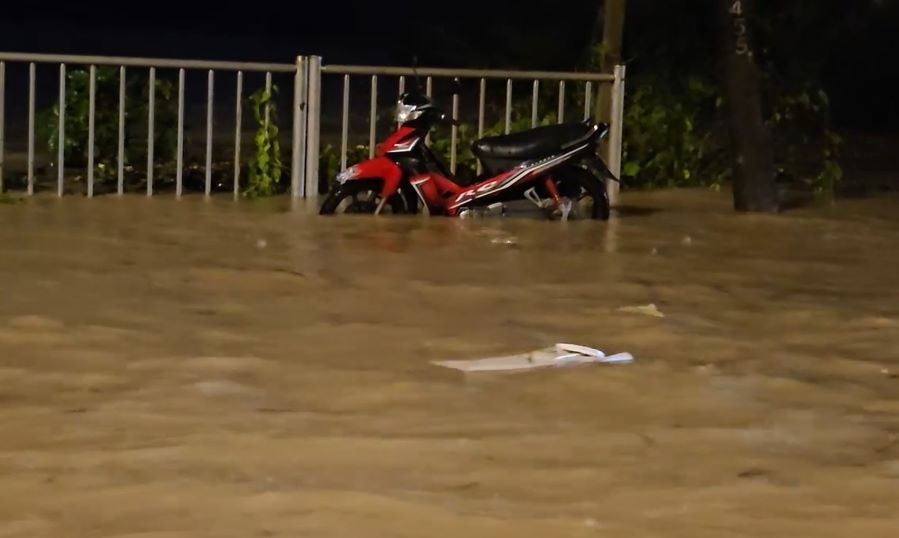 Nước ngập sâu, chảy xiết, người dân bỏ xe để di chuyển đến khu vực an toàn.