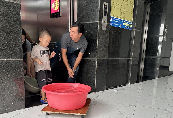 Anh Đinh Văn Chính đi lấy nước sạch sáng 16.10 do cư dân góp tiền mua. Ảnh: Anh Huy. 