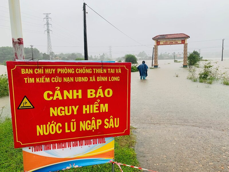 Lực lượng chức năng cắm biển báo tại những tuyến đường bị nước lũ chia cắt ở huyện Bình Sơn, không cho người qua lại. Ảnh: Ngọc Viên
