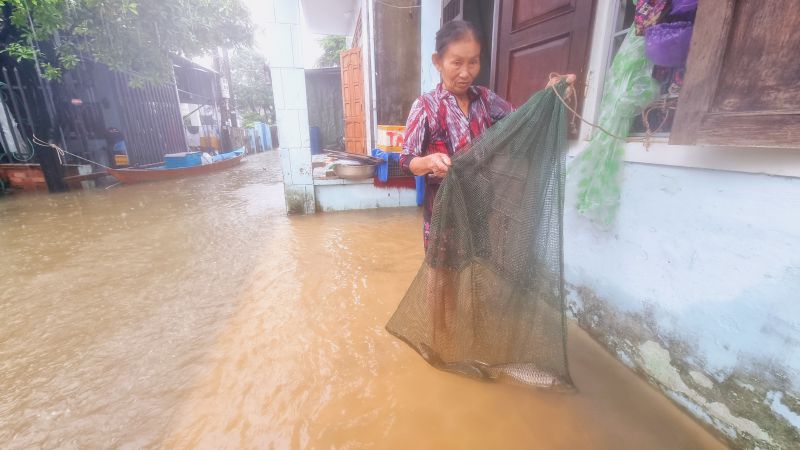 Căn nhà sát bờ sông của bà Phạm Thị Phúc (67 tuổi), bị nước bao lớn bao vây, cá đánh lưới bắt được rọng ngay bên hiên nhà. Ảnh Hoàng Bin.