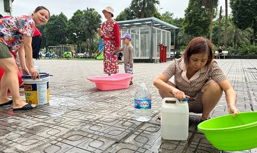 Cư dân ở chung cư trong Khu đô thị Thanh Hà phải dùng xô chậu đi lấy nước sạch. Ảnh: Anh Huy