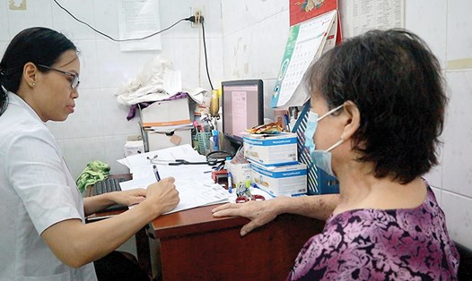 Bác sĩ khám bệnh tại Trạm y tế phường 8, quận Gò Vấp. Ảnh: Nguyễn Ly
