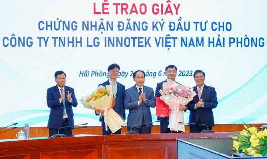 Bí thư Thành ủy Hải Phòng Lê Tiến Châu (đứng giữa) và Chủ tịch UBNDTP Nguyễn Văn Tùng (ngoài cùng bên phải) trao giấy chứng nhận cho nhà đầu tư nước ngoài. Ảnh: Đàm Thanh