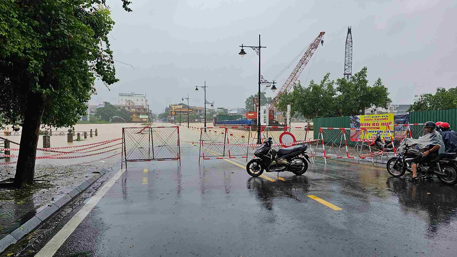 Tại cầu Đập Đá nối đường Lê Lợi với đường Nguyễn Sinh Cung, nước sông đã dâng lên cao, tràn và chảy xiết qua đường.