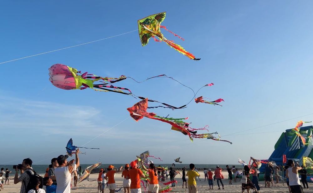 Du khách thích thú thả diều ở biển Phan Thiết. Ảnh: Duy Tuấn