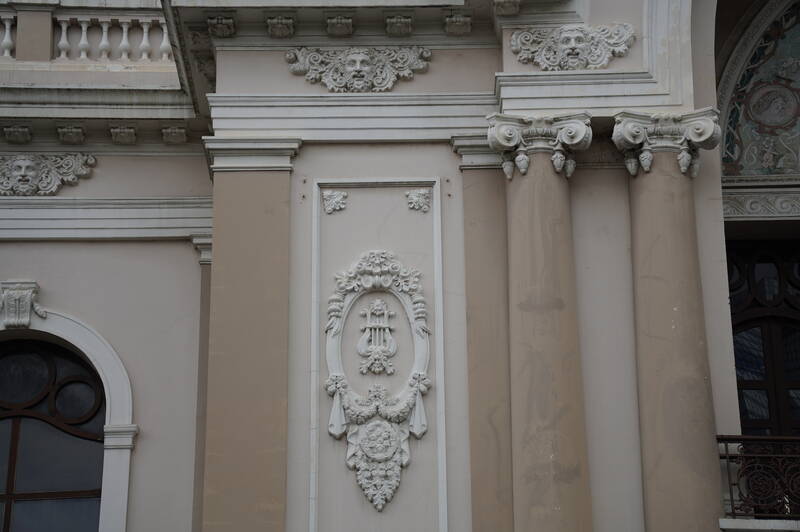 Những bức phù điêu đắp nổi bên ngoài nhà hát là hình ảnh cây đàn, dây hoa, thiên thần, vị thần trang trí quanh mặt tiền, các cột và bên hông nhà hát.