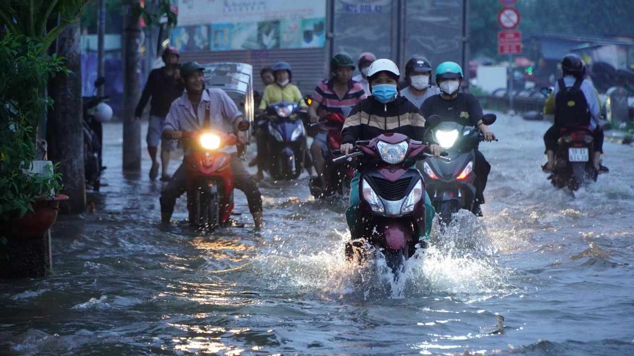 Dòng nước dâng cao khiến việc đi lại, buôn bán của người dân trên đoạn đường này gặp rất nhiều khó khắn.