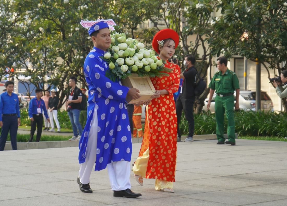 Cặp đôi tham gia lễ cưới tập thể 2023 dâng hoa tại tượng đài Chủ tịch Hồ Chí Minh sáng 20.10. Ảnh: Phương Ngân