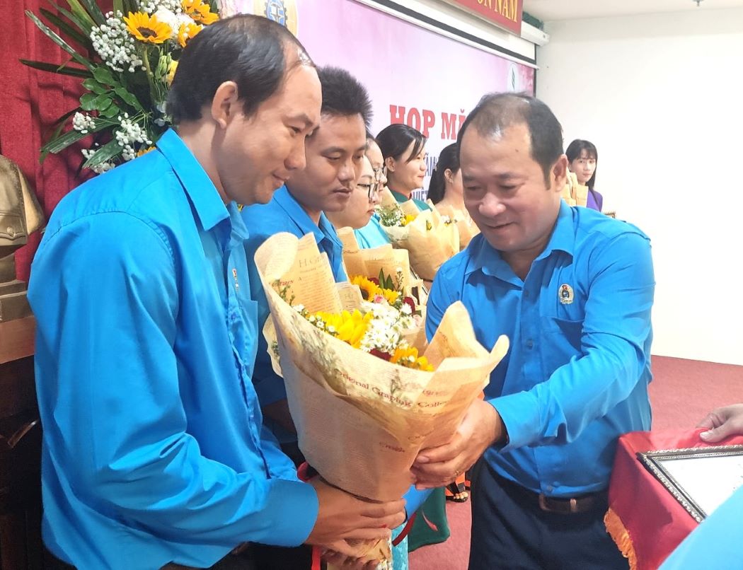 Ông Nguyễn Ngọc Mùi - Phó Chủ tịch Công đoàn Caosu Việt Nam (bên phải) - tặng hoa chúc mừng các tác giả được giải trong cuộc thi ảnh “Hoa Caosu“. Ảnh: Nam Dương